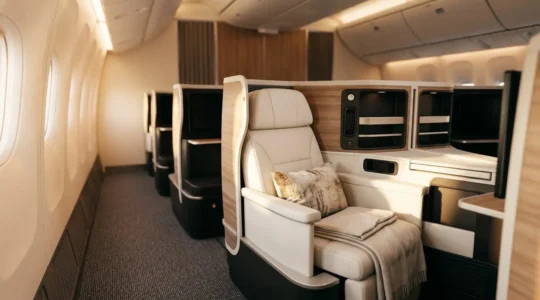 Luxurious business class cabin with lie-flat seats in warm ambient lighting